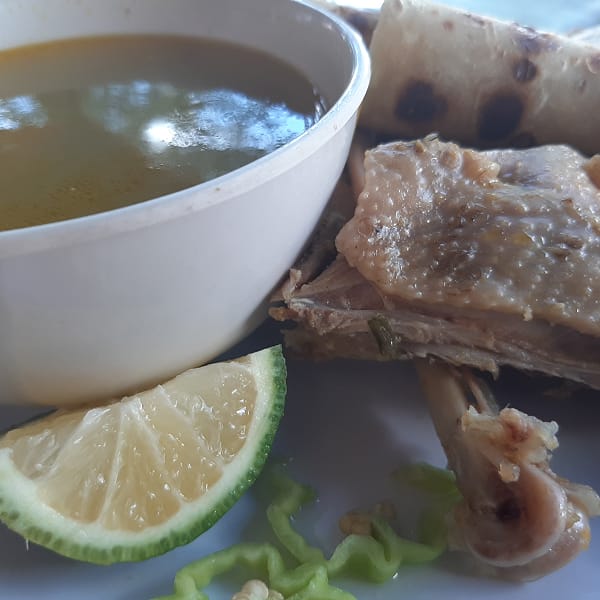 kuku soup served for breakfast in dar es salaam with lemon and chili