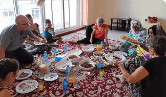 guests enjoying a home cooked meal in zanzibar while sitting on floor
