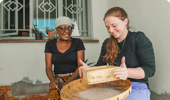 guest learning how to sieve peanut flour during a zambian cooking class