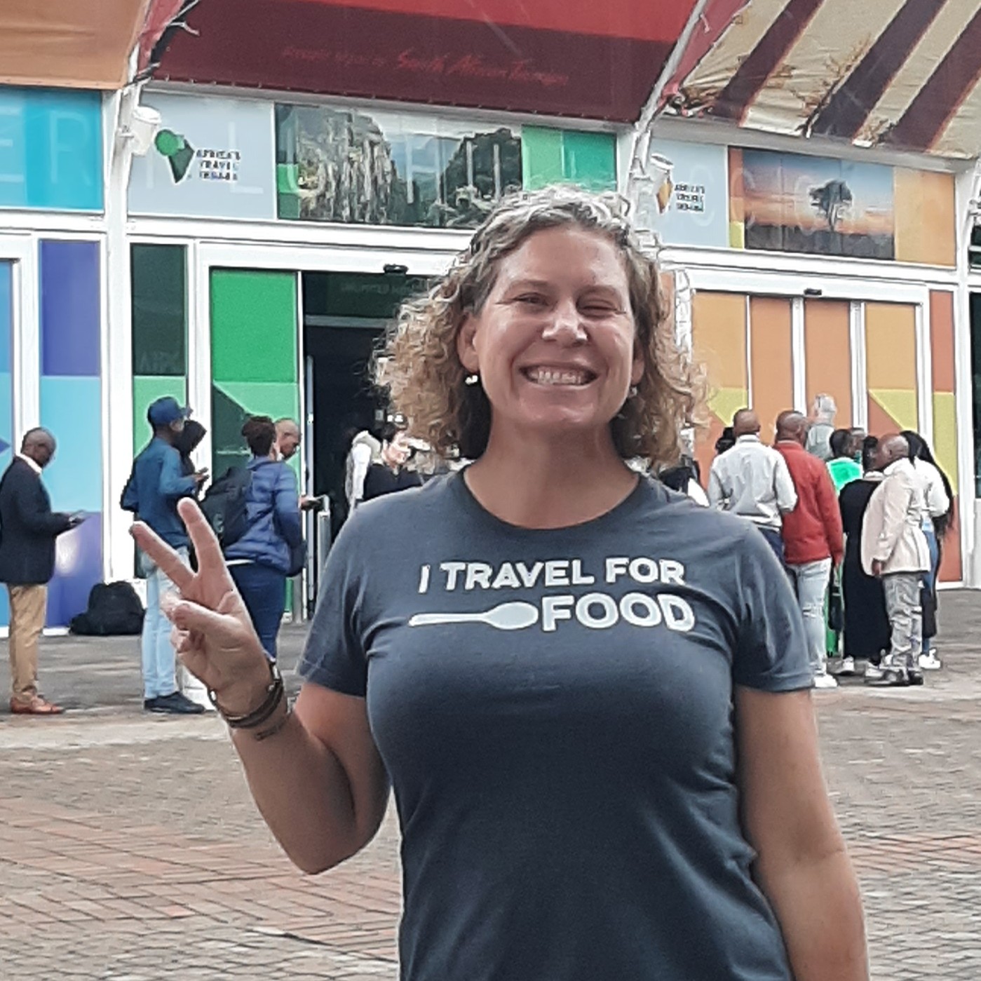jiranileo cofounder elizabeth jere wearing a t shirt that says I travel for food