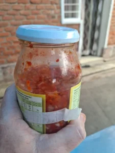jar filled with homemade chili sauce in rwanda