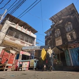 women walk by the entrance to biashara market