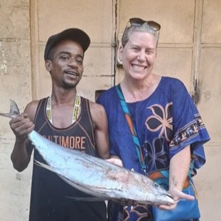 woman and man hold a large fresh tuna